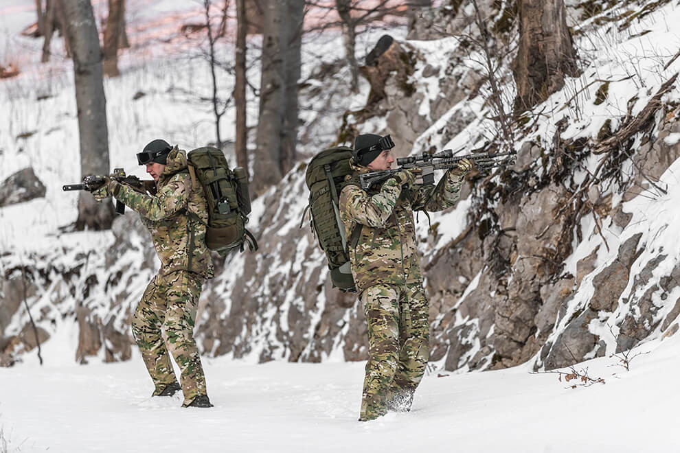 Two operators camouflaged in a forest